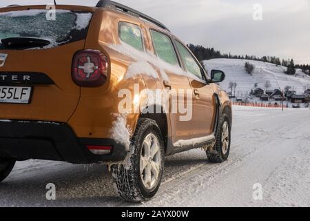 Dacia Duster SUV beim Fahren auf einer verschneiten Straße Stockfoto