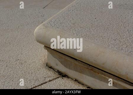Niedrige Steigleitung bequeme Außentreppe eines Steigrohrs. Sich verschlechternde Gelenke. Weicher beigefarbener Kalkstein mit Textur. Abstraktes architektonisches Design Stockfoto