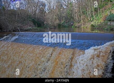 Dean Village, Edinburgh, Schottland, Großbritannien. Februar 2020. Sonnenschein und Duschen den ganzen Tag über mit einem lebhaften Wind. Außergewöhnlich starker Regen über Nacht und ein sehr schnell fließender Wasserfall auf Dem Wasser von Leith direkt neben dem Dean Village. Der Fluss fließt 24 km von seiner Quelle in den Pentland Hills am historischen Well Court vorbei und schlängelt sich durch das Herz der schottischen Hauptstadt bis zu seinem Abfluss in den Firth of Forth bei Leith. Stockfoto