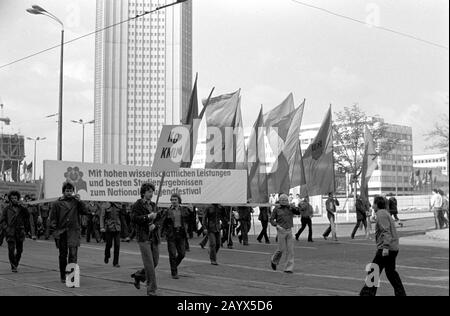 01. Mai 1979, Brandenburg, Leipzig: Die Demonstration am 1. Mai 1979 in Leipzig am Ring, in der "DDR als internationaler Tag Des Kampfes und Feiertags Der Arbeiter für Frieden und den Nationalsozialismus" bezeichnet. Gegenüber der Oper befand sich die Tribüne, an der die Demonstrationsteilnehmer vorbeigingen, hier Studenten der Leipziger Karl-Marx-Universität (KMU) mit dem Banner "Mit hohen wissenschaftlichen Leistungen und besten Studienergebnissen für das Landesjugendfest". Im Hintergrund der sogenannte Hochschulriese. Foto: Volkmar Heinz / dpa-Zentralbild / ZB Stockfoto