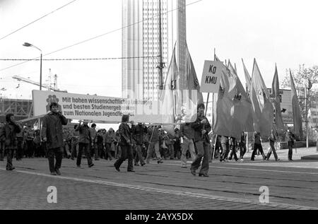 01. Mai 1979, Brandenburg, Leipzig: Die Demonstration am 1. Mai 1979 in Leipzig am Ring, in der "DDR als internationaler Tag Des Kampfes und Feiertags Der Arbeiter für Frieden und den Nationalsozialismus" bezeichnet. Gegenüber der Oper befand sich die Tribüne, an der die Demonstrationsteilnehmer vorbeigingen, hier Studenten der Leipziger Karl-Marx-Universität (KMU) mit dem Banner "Mit hohen wissenschaftlichen Leistungen und besten Studienergebnissen für das Landesjugendfest". Im Hintergrund der sogenannte Hochschulriese. Foto: Volkmar Heinz / dpa-Zentralbild / ZB Stockfoto