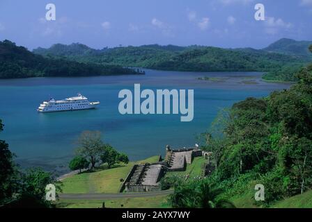 Kreuzfahrtschiff Americana (ehemalige Yorktown Clipper) vor Anker vor der Festung Portobelo, die zum UNESCO-Weltkulturerbe in der Provinz Colón, Panam gehört Stockfoto