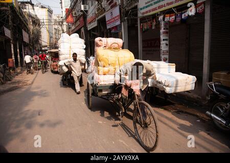 Händler machen sich auf den Weg durch die überfüllten Straßen des Marktes in Dehli, Indien. Stockfoto