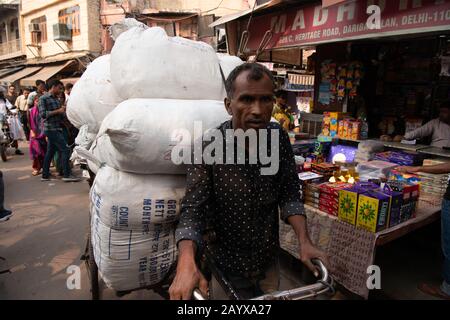 Händler machen sich auf den Weg durch die überfüllten Straßen des Marktes in Dehli, Indien. Stockfoto