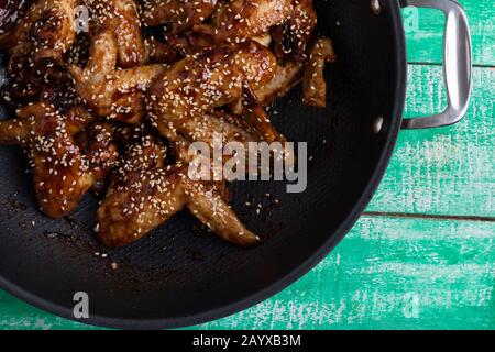 Nahaufnahme von einem thai Rezept mit karamellisierten Hähnchenflügel in einem wok Stockfoto