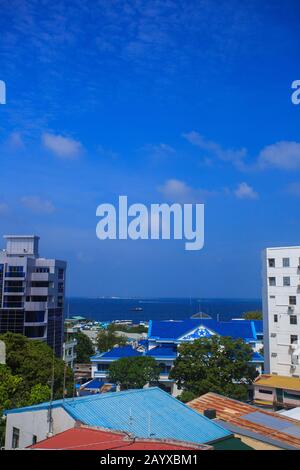 Mehrstöckige Gebäude von Male City (Malediven). Blaues Wasser des Indischen Ozeans ist in einer Entfernung sichtbar. Stockfoto