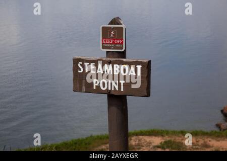 Ein Holzschild, das Steamboat Point mit einem kleineren Schild oben kennzeichnet, warnt davor, sich vom Thermalgebiet am Ufer des Yellowstone Lake mit zu halten Stockfoto