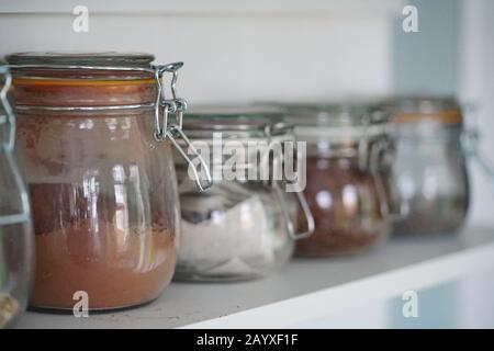 Glasgefäße, Kunststoffverpackungen, Gesundheitsnahrung, viele Gläser in Regalen Stockfoto