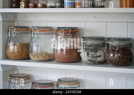 Glasgefäße, Kunststoffverpackungen, Gesundheitsnahrung, viele Gläser in Regalen Stockfoto