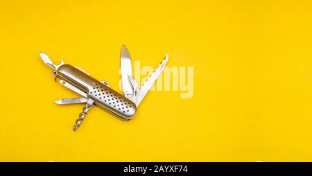 Nahaufnahme des Schweizer Armeemessers auf gelbem Hintergrund mit Kopierraum Stockfoto