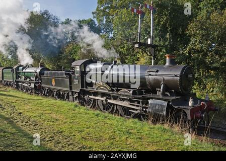 Ein Doppelkopfzug mit 6960 Raveningham Hall und 7822 Foxcote Manor, der auf der West Somerset Railway einen Regen in Richtung Minehead zog. Stockfoto