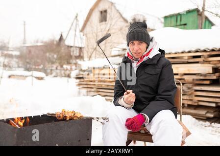 Eine Frau mit einer Schashlik auf einem Shampoo, im Winter. Stockfoto