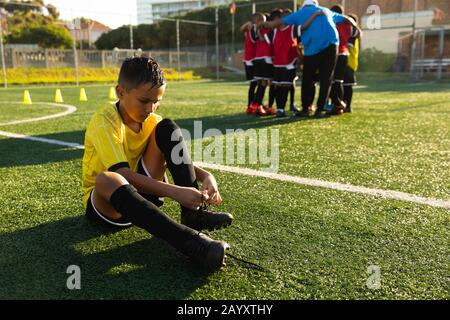 Vorderansicht Fußballspieler, der seine Schuhe aufsetzt Stockfoto