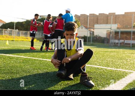 Vorderansicht Fußballspieler, der seine Schuhe aufsetzt Stockfoto