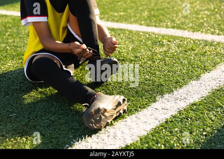 Vorderansicht Fußballspieler, der seine Schuhe aufsetzt Stockfoto