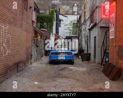 Schönes Auto, das in einer heruntergekommenen Gegend in der Innenstadt von Toronto geparkt wurde. Stockfoto