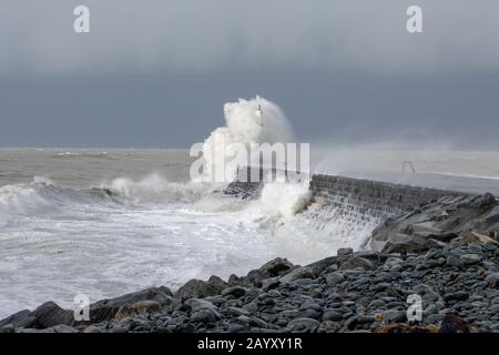 Die Sturmwinde, die über 60mph Uhr stürmen, und die morgendliche Flut verbinden sich und bringen riesige Wellen über die Irische See, um Aberystwyth zu schlagen. Stockfoto