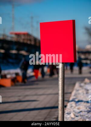 Modernes rotes Rechteckschild aus Metall mit leerem Leerzeichen für die Vorlage. Außenwerbung. Hintergrund löschen. Straßenschild auf hohem Stahlbein verspottete. Stockfoto