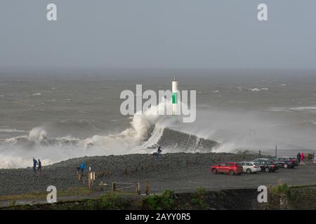 Die Sturmwinde, die über 60mph Uhr stürmen, und die morgendliche Flut verbinden sich und bringen riesige Wellen über die Irische See, um Aberystwyth zu schlagen. Stockfoto