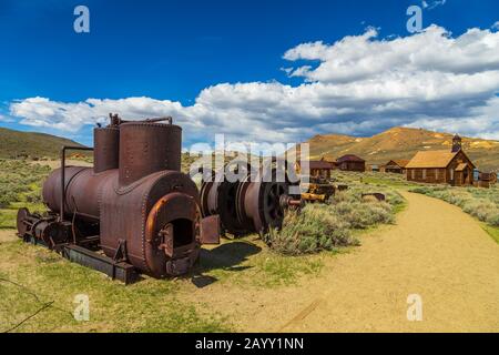 Bodie, Kalifornien, USA- 03. Juni 2015: Geisterstadt, Bodie States Historic Park. Abgebrochene Artefakte. Die methodistische Kirche und das Holzgebäude im Rücken Stockfoto