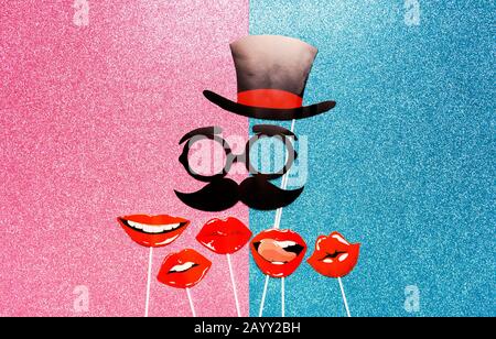 Flatlay Overhead Oberteil schwarzes Papier Fotostand Requisiten Lippen und Schnurrbart und Hut, Symbol des reifen Mannes auf pinkfarbenem und blauem Hintergrund Kopierraum Stockfoto