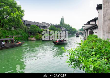 Wuzhen, China. August 2015. Touristenboote auf den Wasserkanälen in der Wasserstadt Wuzhen an einem übergiebelten Tag in der chinesischen Provinz Zhejiang. Stockfoto