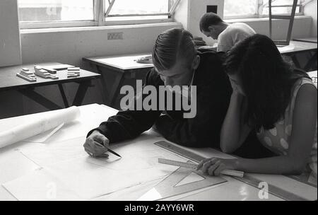 In den 1960er Jahren studieren historische, männliche und weibliche Studenten eine technische Zeichnung auf einem Tisch, der nebeneinander in einer Klasse sitzt, der University of Southern California, USA Stockfoto