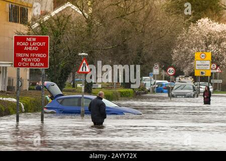 NANTGARW, IN DER NÄHE VON CARDIFF, WALES - FEBRUAR 2020: Menschen, die auf dem Treforest Industrial Estate durch Hochwasser wateln, während es in das Dorf Nantgarw eindringt, Stockfoto