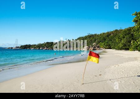 Flagge auf Anse Lazio, einem der berühmtesten Strände der Praslin-Inseln, den Seychellen Stockfoto