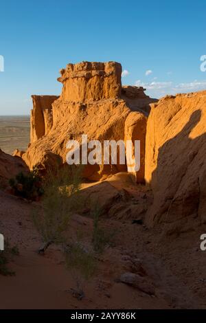 Die orangefarbenen Felsen von Bayan Zag, die im Allgemeinen als Flaming Cliffs in der Wüste Gobi, der Mongolei, bekannt sind und in denen wichtige Dinosaurier-Fossilien gefunden wurden. Stockfoto