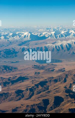 Blick auf das schneebedeckte Altai-Gebirge (Altay-Gebirge) in der Nähe von Ulgii auf dem Flug von Ulaanbaatar nach Ulgii (Ölgii) in der westlichen Mongolei. Stockfoto