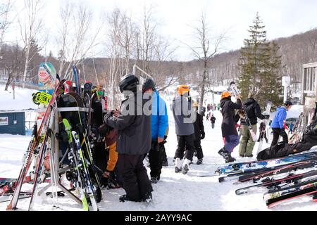 Skifahrer parken ihre Ausrüstung, bevor sie in Camp Fortune, Chelsea, Quebec, Kanada nach einem Apres Ski fahren. Stockfoto