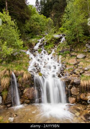 Ein kleiner Wasserfall in der Nähe eines Dorfes von Encamp, Andorra. Das Hotel liegt im Pyrenäengebirge. Lange Belichtung Stockfoto