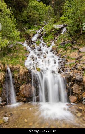 Ein kleiner Wasserfall in der Nähe eines Dorfes von Encamp, Andorra. Das Hotel liegt im Pyrenäengebirge. Lange Belichtung Stockfoto