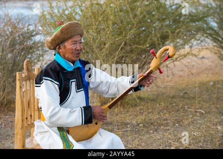 Herr Samjid (80 Jahre alt) aus der ethnischen Minderheit der Uriankhai-Stamm (Uriyangkhai, Urianhai oder Uryangkhai) führt traditionelle Lieder mit auf Stockfoto