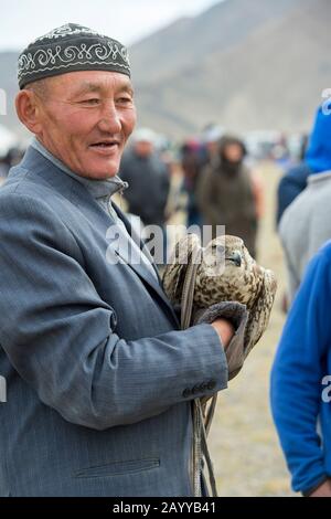Ein Mann, der einen Sakerfalke (Falco cherrug) auf dem Festival Golden Eagle Festival auf dem Festivalgelände in der Nähe der Stadt Ulgii (Ölgii) in der Bayan-Ulgii Pr veranstaltet Stockfoto