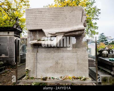 Grabstein von Oscar Wilde aus weißem Stein mit einem Engel mit großen Flügeln geschnitzt, Blumen und andere Grabkapellen rund um und Herbstbäume Stockfoto