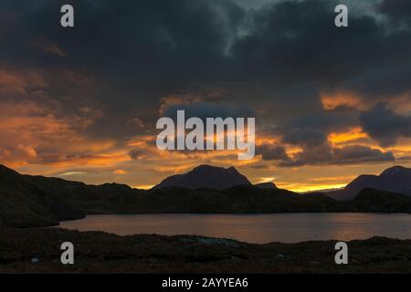 Sonnenaufgang über den Gipfeln Cul Mòr und Cùl Beag, von Loch Buine Mòire, Coigach, Wester Ross, Highland Region, Schottland, Großbritannien Stockfoto