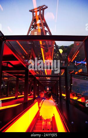 Beleuchtete Gangway und Kopfbedeckung des Kohle-Bergwerks-Industriekomplexes Schacht XII des Zollvereins am Abend, Deutschland, Nordrhein-Westfalen, Ruhrgebiet, Essen Stockfoto