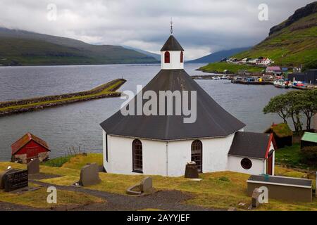Achteckige Kirche im kleinen Dorf Haldarsvik mit Blick auf den Atlanischen Ozean, die Färöer, Streymoy, Haldarsvik Stockfoto
