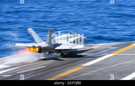 Ein Kampfflugzeug der US Navy F/A-18C Hornet mit dem Todesrattern der Marine Fighter Attack Squadron 323 nimmt vom Flugdeck an Bord des Flugzeugträgers der Nimitz-Klasse USS Nimitz 4. Februar 2020 im Pazifischen Ozean ab. Stockfoto