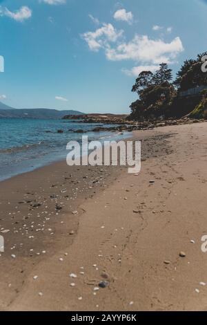 Opossum BAY, TASMANIEN - 16. Februar 2020: Blick auf Opossum Bay Beach an einem sonnigen Sommertag mit niemandem am Strand mit tiefblauem Wasser und klarem s Stockfoto