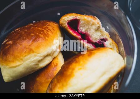 Brötchen mit roter Marmelade in einem Glasbecher. Süße Speisen Stockfoto