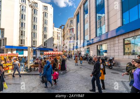 Lokale Türken mischen sich mit Touristen, während Straßenhändler frisches Mais auf den Straßen von Istanbul, Türkei, verkaufen. Stockfoto