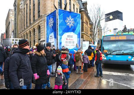 Ottawa, Kanada - 16. Februar 2020: Die Menschen warten in Linie auf die Sparks Street, bis der Snow Bus sie zu einem anderen Ort des jährlichen Winterlude F bringt Stockfoto