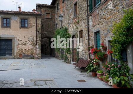 Häuser mit Blumen im befestigten Dorf Montefioralle in der Toskana, Italien, in der Nähe der Stadt Greve in der Chianti-Region. Stockfoto