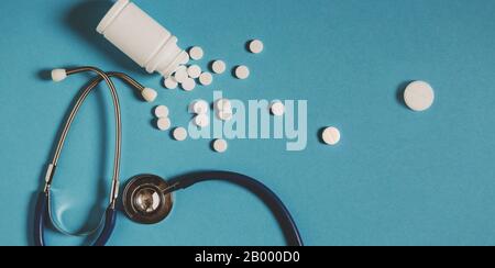 Weiße Pillen, Flasche Und Stethoskop Auf Blauem Hintergrund, Draufsicht. Medizin Gesundheitswesen Pharmazie Coronavirus in China Konzept Stockfoto