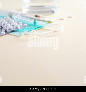 Haufen von Medikamenten, Behandlung mit der kalten Grippe. Viraler Angriff. Set für die Behandlung mit Grippe - Pillen, Kapseln, Thermometer, chirurgische Schutzmaske, Spritze. Kopierbereich. Stockfoto