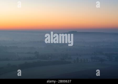 Blick vom Martinsell Hill auf einen nebligen Wintermorgen bei Sonnenaufgang. In der Nähe von Oare, Vale of Pewsey, Wiltshire, England Stockfoto