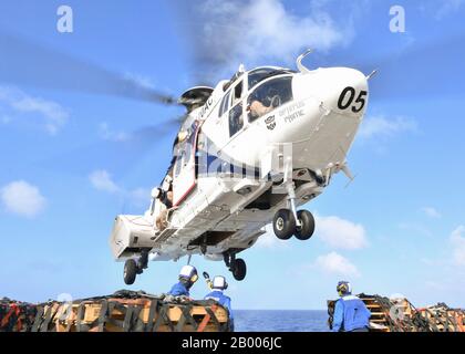 Philippinisches MEER (Feb. 14, 2020) die Segelschiffe bereiten vor, während eines vertikalen Nachschubs auf See an Bord des Docklandungsschiffs "USS Germantown" der Insel (LSD 42) Ladung an einen Aerospatiale SA 330J Puma von Trockenfracht- und Munitionsschiff USNS Richard E. Byrd (T-AKE 4) anzuhängen. Germantown, Teil der America Expeditionary Strike Group, 31. Marine Expeditionary Unit Team, ist im 7. US-Flottengebiet tätig, um die Interoperabilität mit Verbündeten und Partnern zu verbessern und dient als einsatzbereite Einsatzkräfte zur Verteidigung von Frieden und Stabilität in der Region Indopazifik. (USA Navy-Foto von Mass Communicati Stockfoto